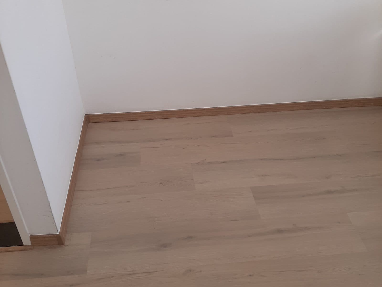 Lege kamer met witte wanden en laminaatvloer, bezemschoon opgeleverd na verhuizing