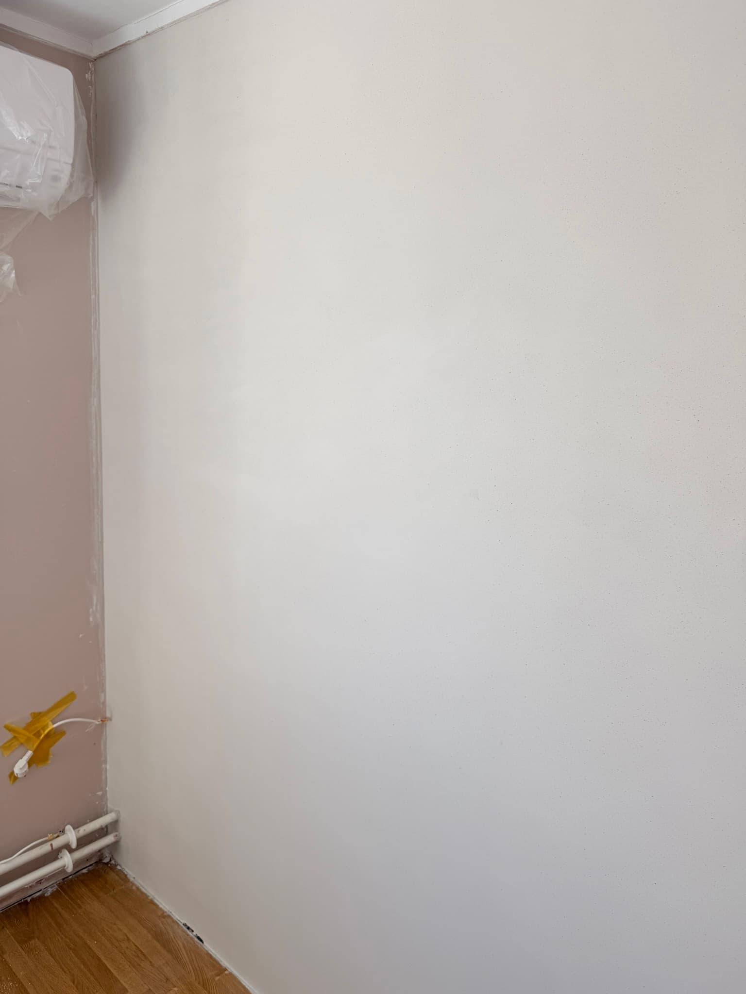 Stukadoor brengt glad stucwerk aan op een woonkamerwand in Maastricht